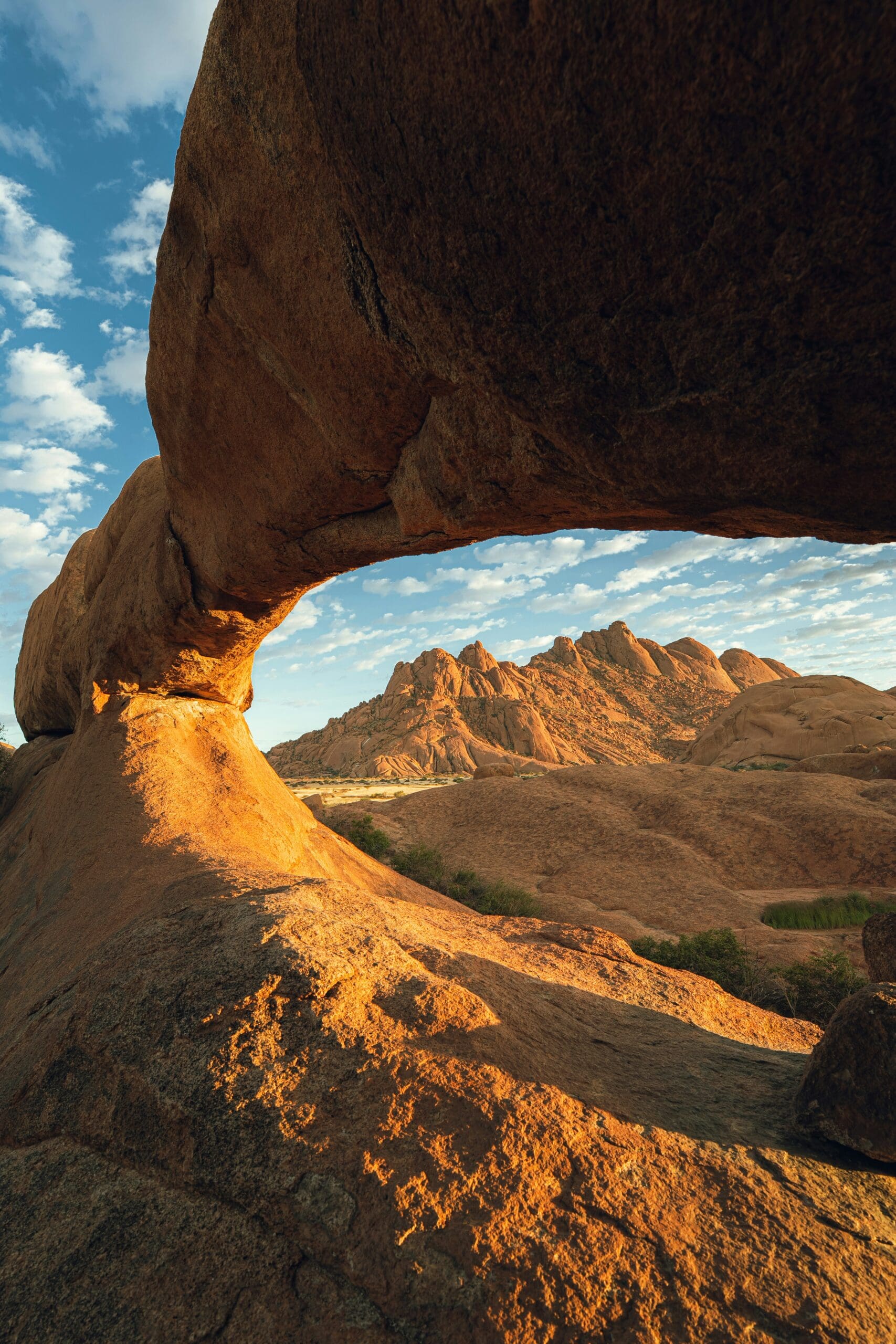 Desert rock arch framing mountains, symbolizing grounding and nervous system regulation in somatic therapy